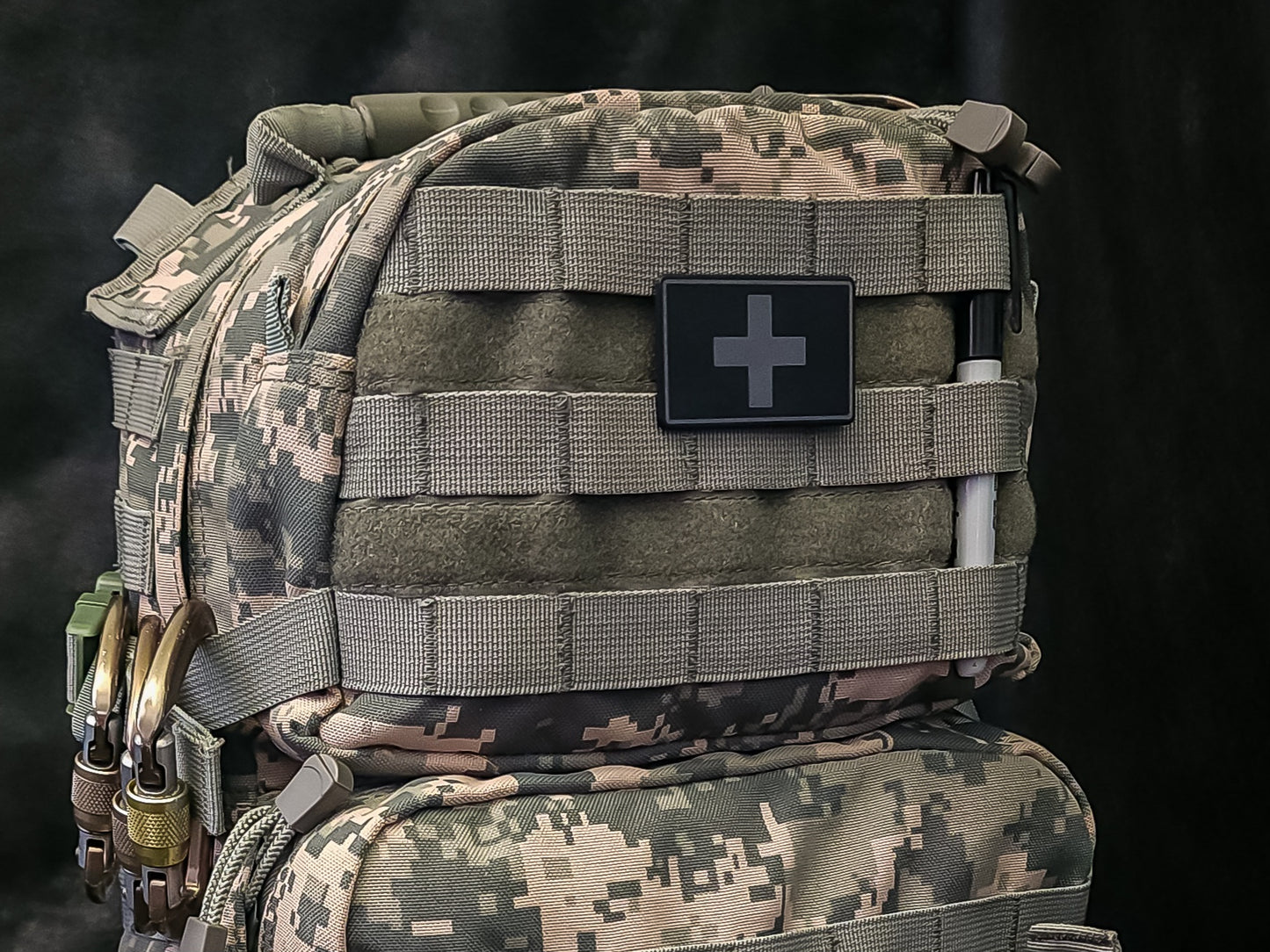 MOLLE Medical ID Tags attached to a tactical backpack for emergency identification and first aid supplies.
